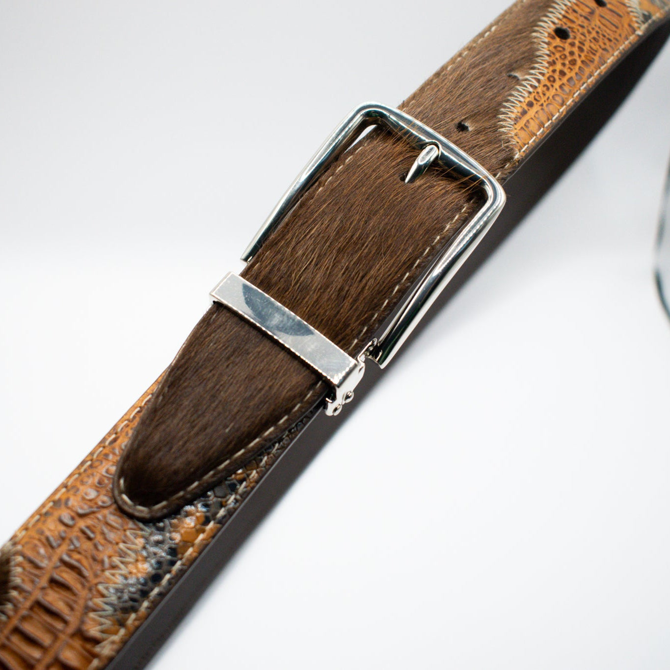 Brown leather belt with a silver buckle on a white background