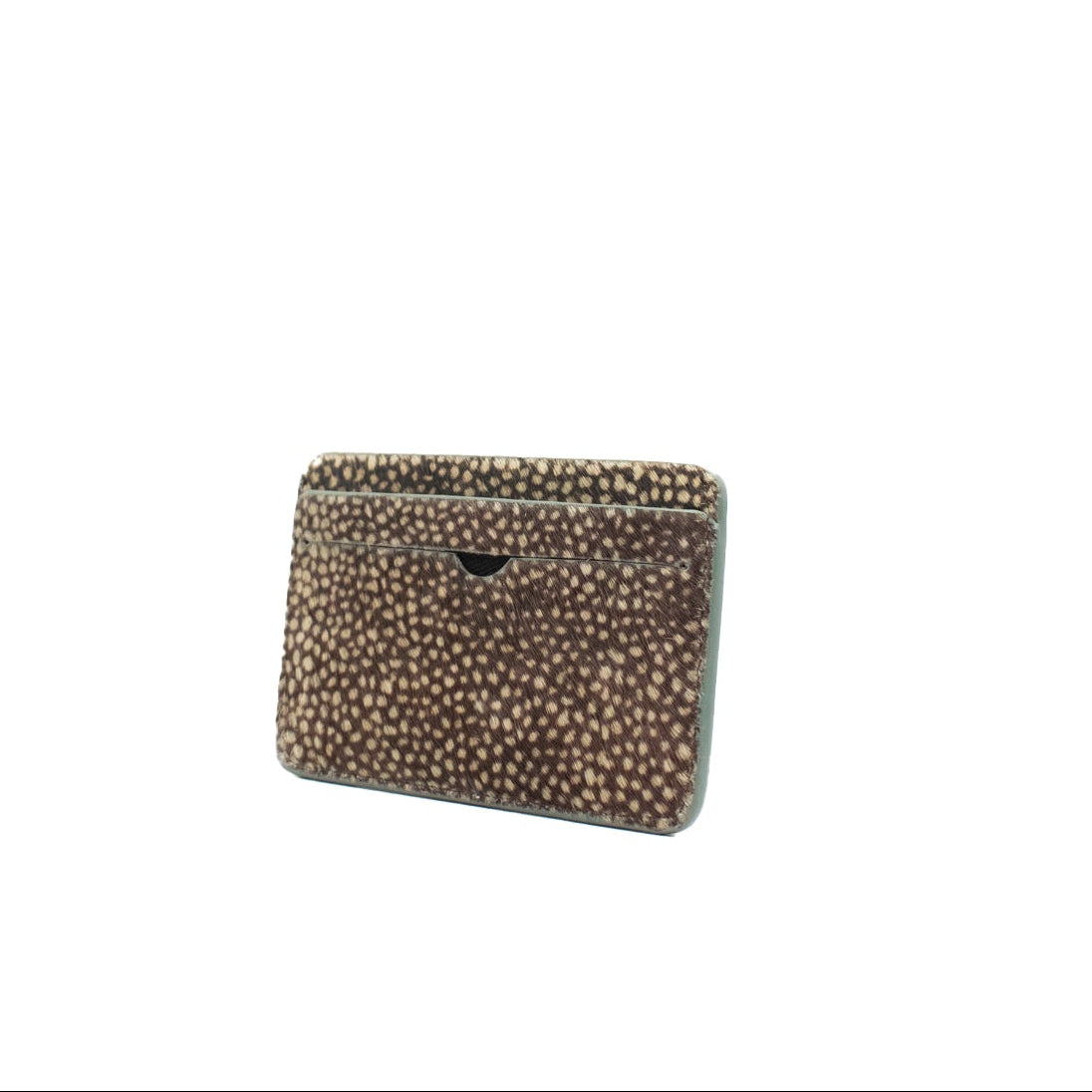 Small rectangular cardholder made of cowhair in a dot pattern with a textured pattern on a white background