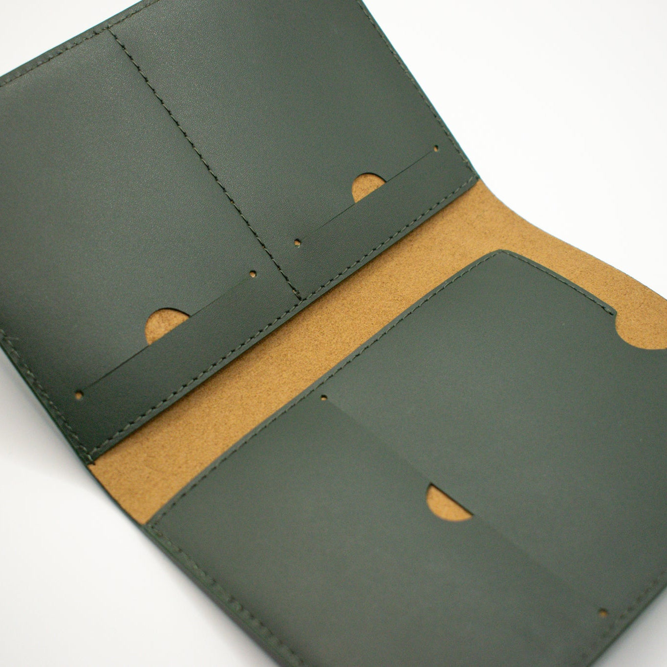 Green leather wallet with tan microfibre interior on a white background
