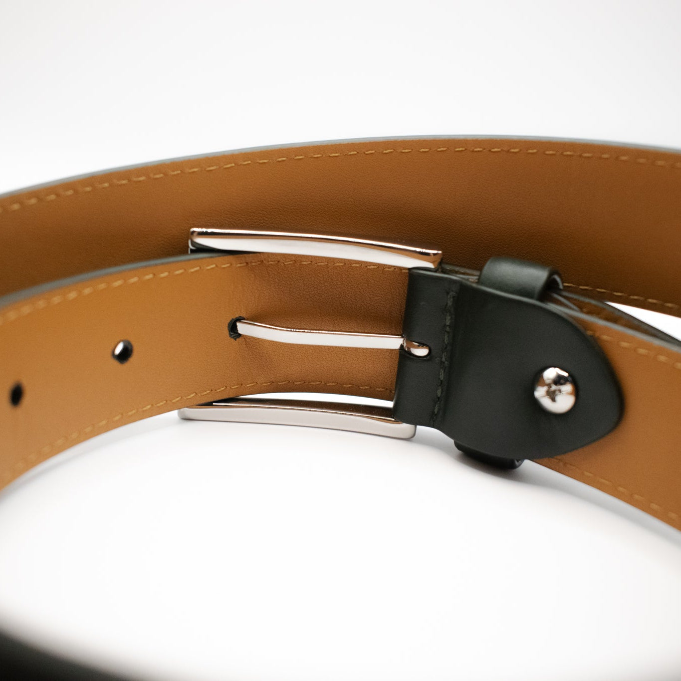 Close-up of a brown leather belt with a silver buckle on a white background