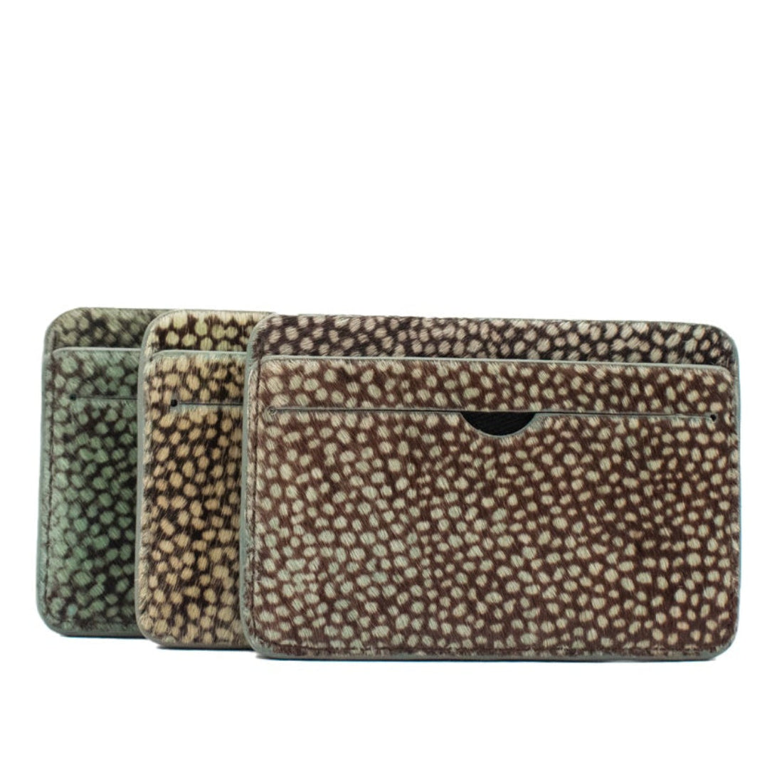 three cowhair printed with dots cardholder wallets on a white background