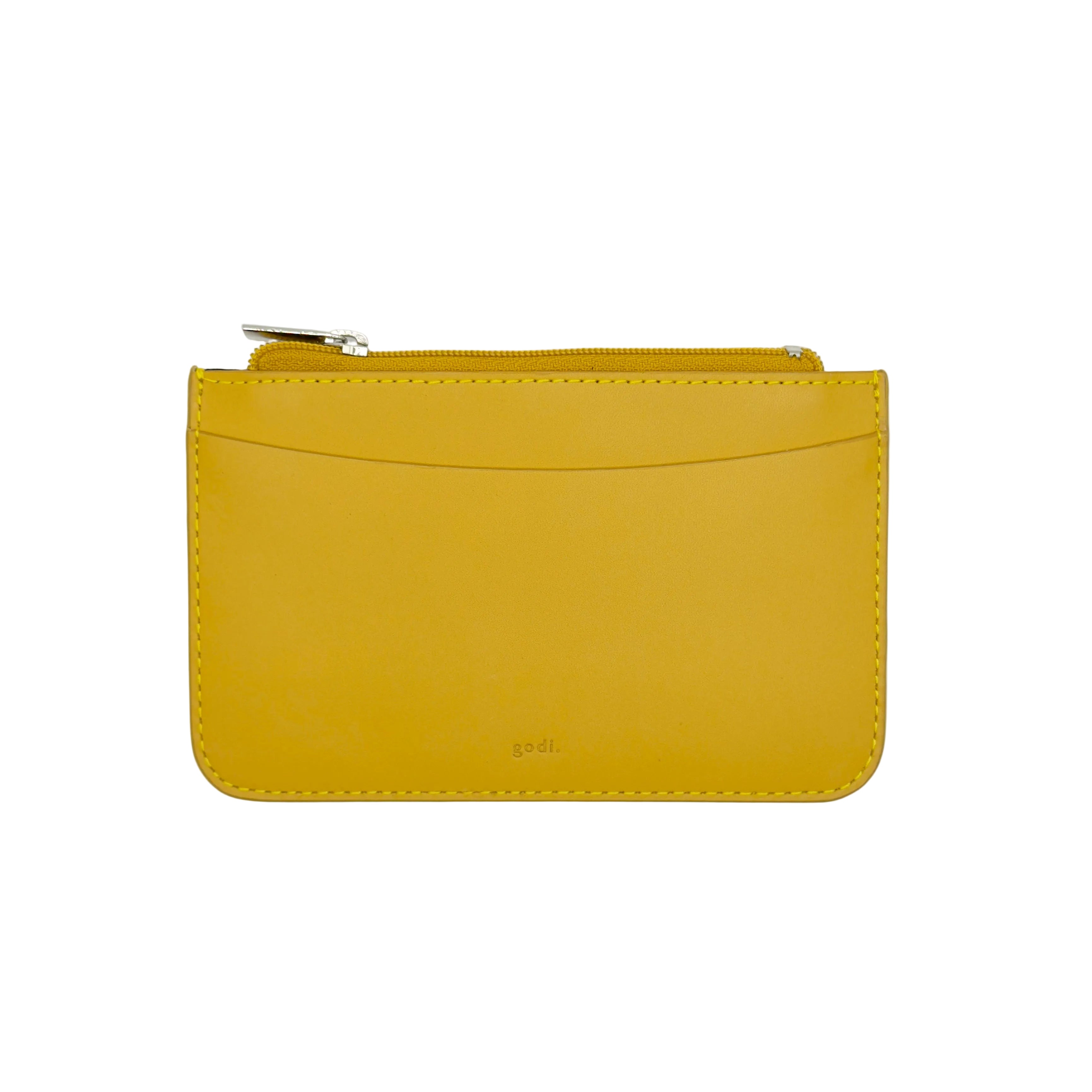 A small mustard yellow leather zip pouch with a curved front pocket and silver zipper pull, photographed flat against a clean white background.