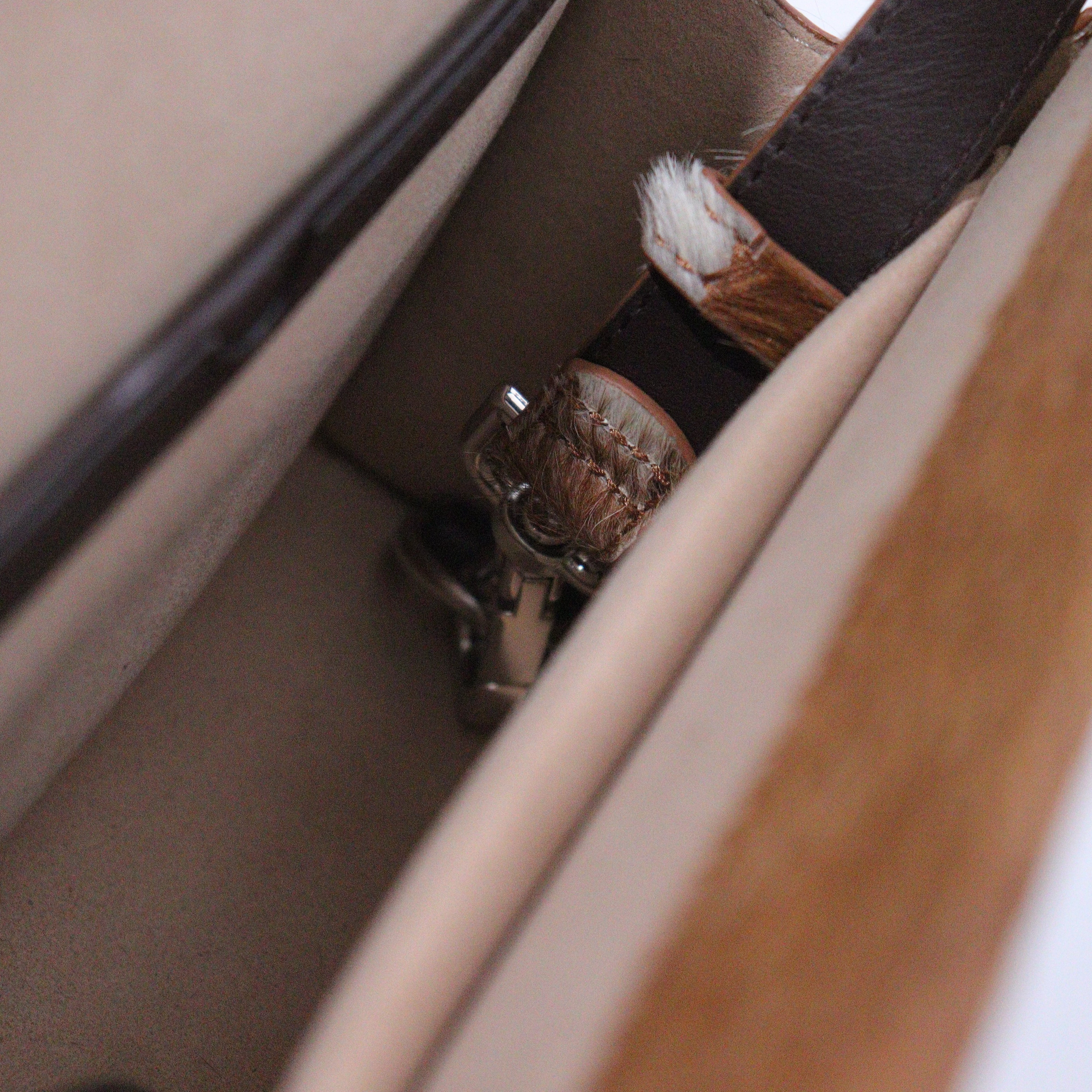 Close-up of a belt with a buckle on a bags surface